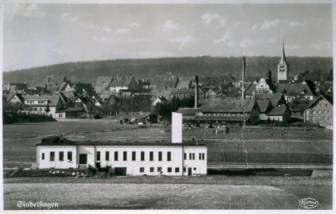 Im Vordergrund befindet sich die katholische Notkirche im Hintergrund die evangelische Martinskirche.Bei der Fabrik mit den zwei Schornsteinen handelt es sich um die Ziegelei Hamm, dahinter die ehemalige Gartenstraßenschule. Sie wurde 1936 in Horst-Wessel-Schule umbenannt.
