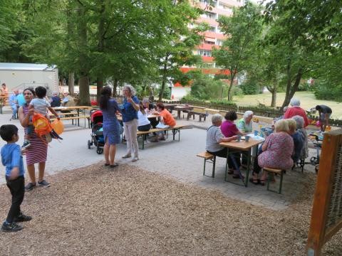 Familienzentrum Außenbereich, Menschen am unterhalten, sitzen auf Bierbänken