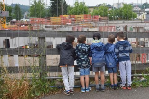 Fünf Kinder betrachten eine Baustelle 