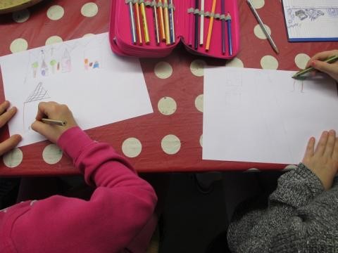 Zwei Kinder zeichnen auf weißes Papier.