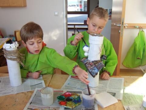 Zwei Kinder basteln aus Rollen, Papier und Kleister Türme im Atelier
