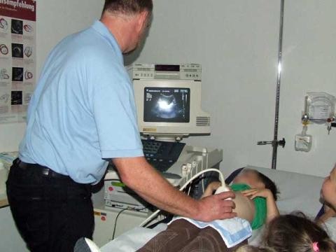 Ein Arzt untersucht ein Kind mit Ultraschall