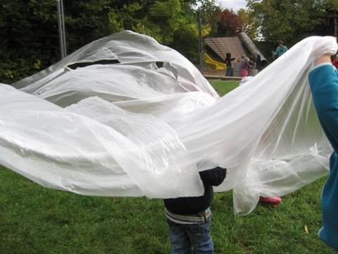 Kinder experimentieren mit einem Stoff zum Thema Luft