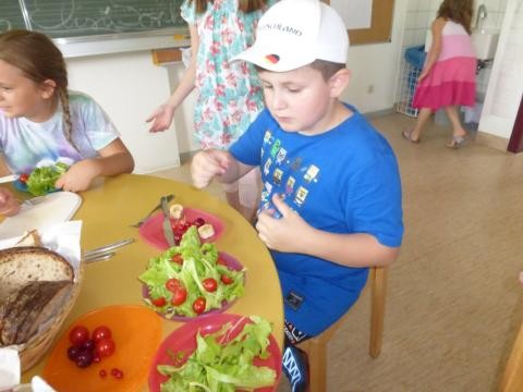Kind beim Essen von selbstgezogenem Gemüse