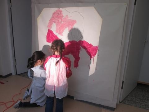 2 Kinder malen vor der Malwand