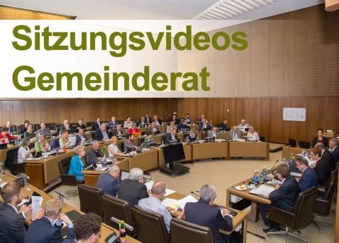 viele Menschen sitzen in einem Raum. Schriftzug: Sitzungsvideos Gemeinderat.