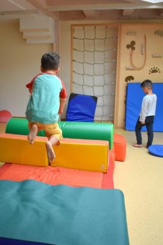 Kind springt über Matten in der Turnhalle 
