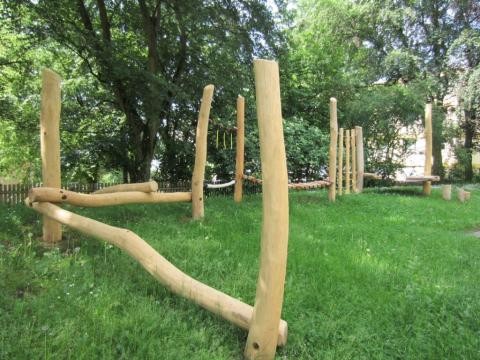 Installation aus Holzstämmen auf der Wiese in verschiedener Anordnung