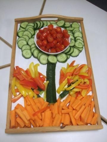 Karotten, Paprika, Gurken und Tomaten sind zu einer Blume gestaltet