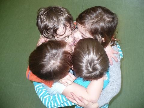 Vier Kinder halten sich fest im Arm
