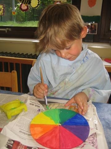 Ein Junge malt einen Farbkreis an