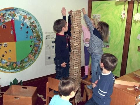 Kinder bauen aus Bauklötzen einen hohen Turm