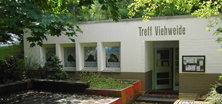 Gebäude mit Bepflanzung und "Treff Viehweide"